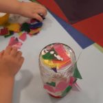 Kind beklebt Glas mit Transparentpapier, Windlicht basteln, Herbst, Elementar